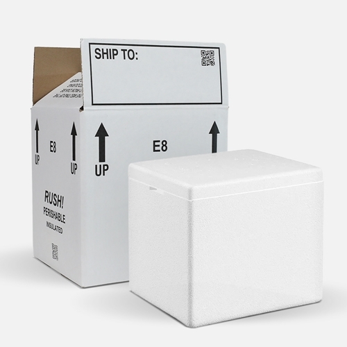 White insulated foam cooler placed next to an open white cardboard shipping box. The box is labeled ‘RUSH! PERISHABLE INSULATED,’ with arrows indicating ‘UP’ and a blank ‘SHIP TO:’ section on the flap.